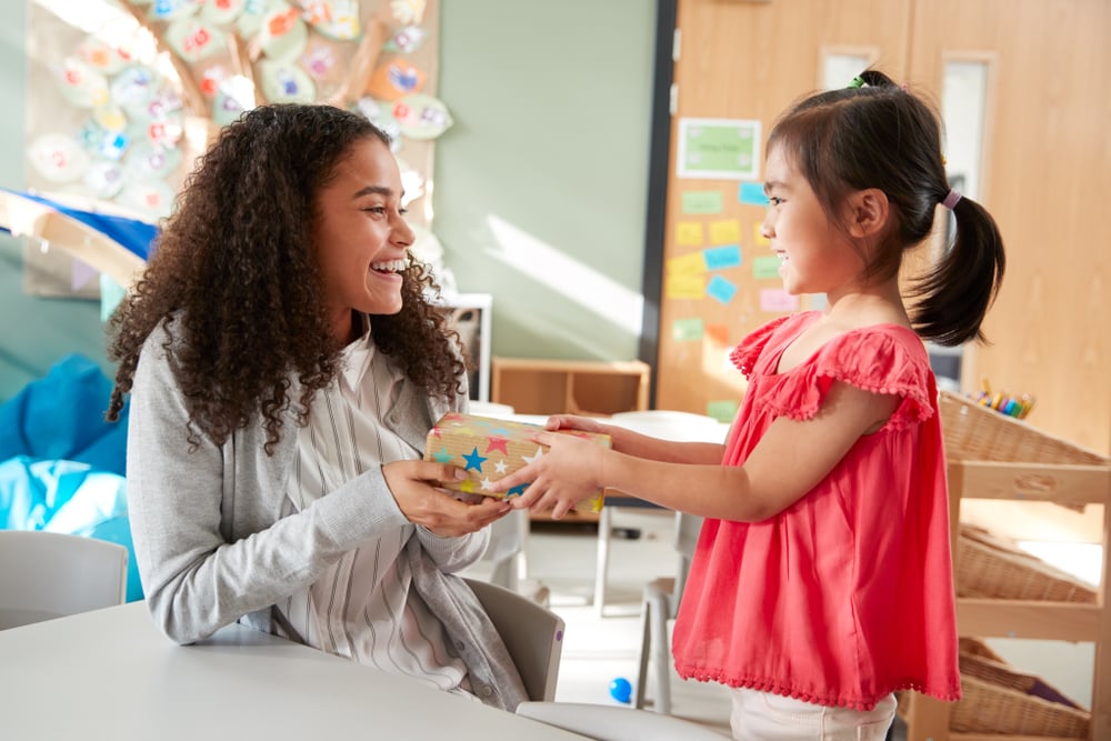 Kindergarten,schoolgirl,giving,a,gift,to,her,female,teacher,in