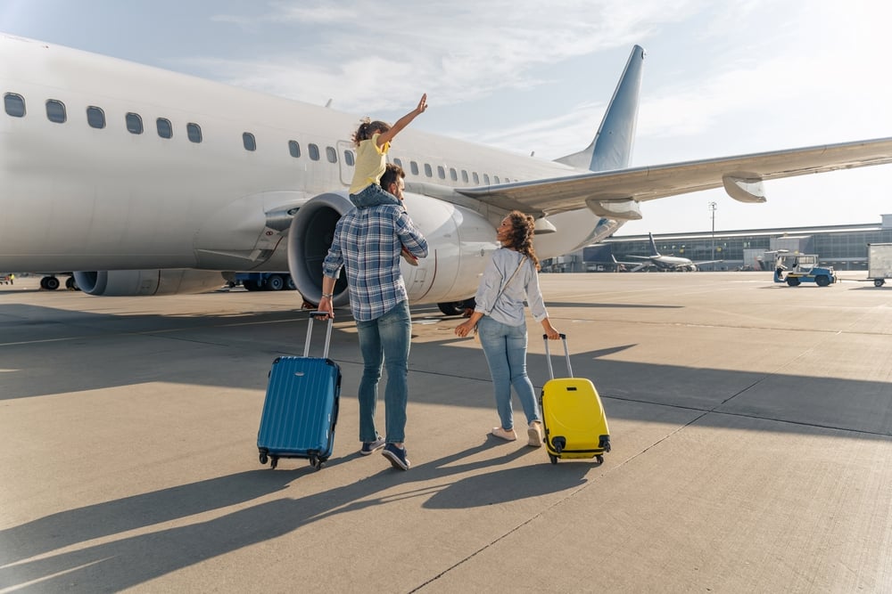 Back,view,of,happy,family,standing,near,a,large,plane